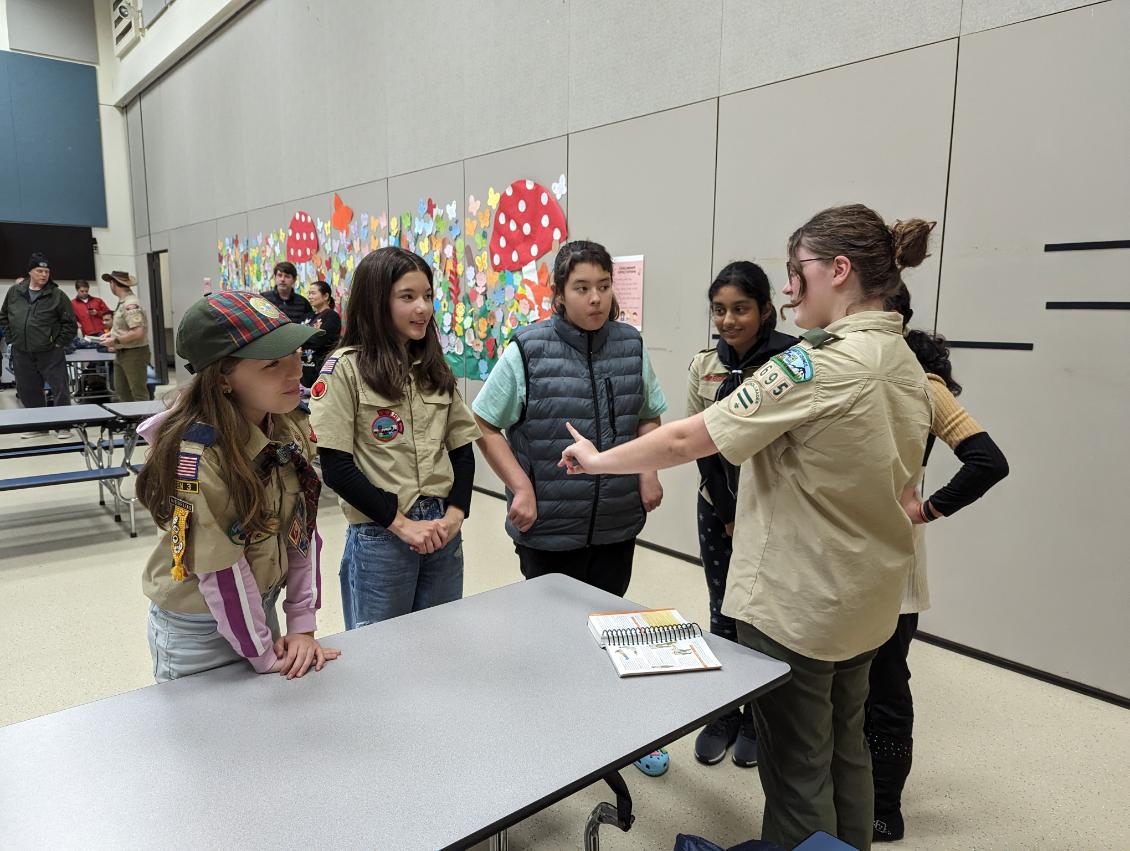 Troop 8695, a female-led scout troop, discussing their plans to tackle their next project.